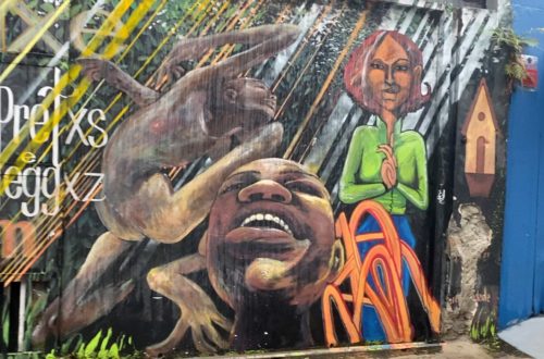 Mural urbano en São Paulo con rostros expresivos y figuras en colores vivos
