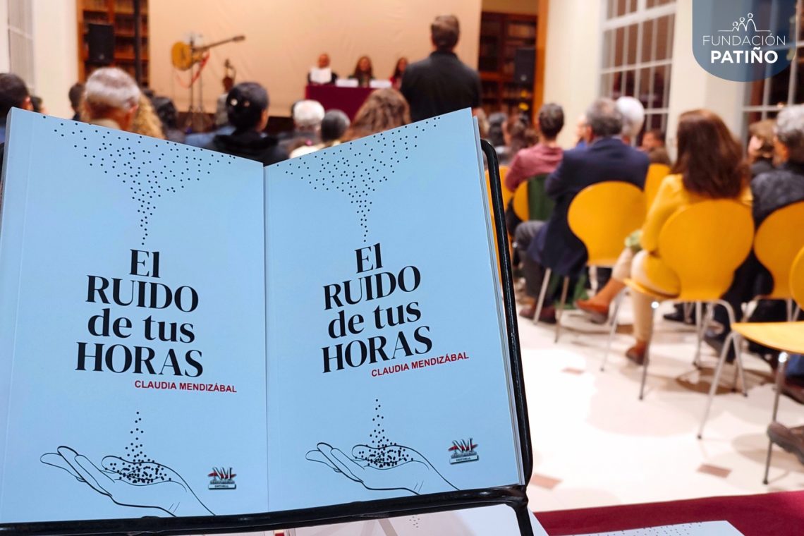 Ejemplares impresos de la novela El ruido de tus horas, con el público asistente en segundo plano