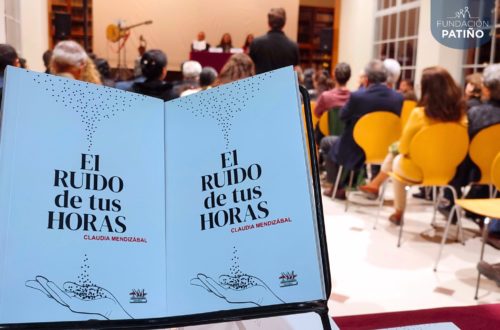 Ejemplares impresos de la novela El ruido de tus horas, con el público asistente en segundo plano