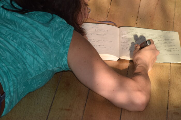 Escritura al ras del suelo; cuerpo y cuaderno.