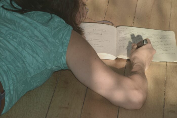 Escritura al ras del suelo; cuerpo y cuaderno.
